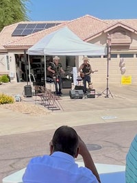 a group of people sitting at a table in front of a house