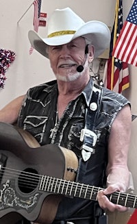 a man in a cowboy hat holding an acoustic guitar
