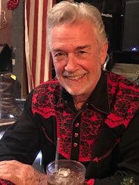 a man sitting at a table with a drink in front of him
